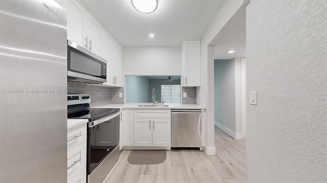 15805 W Waterside Cir Unit 202, Sunrise, FL 33326 - kitchen with stainless steel appliances, a sink, a textured wall, tasteful backsplash, and light countertops
