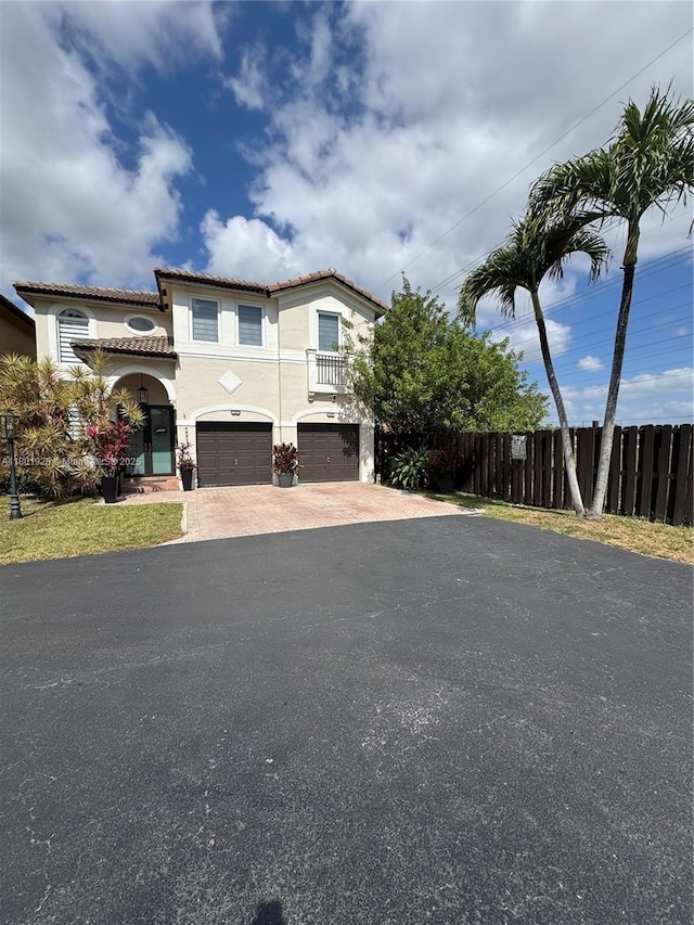 4892 NW 109th Pl, Doral, FL 33178 - view of front facade with decorative driveway, fence, stucco siding, an attached garage, and a tiled roof
