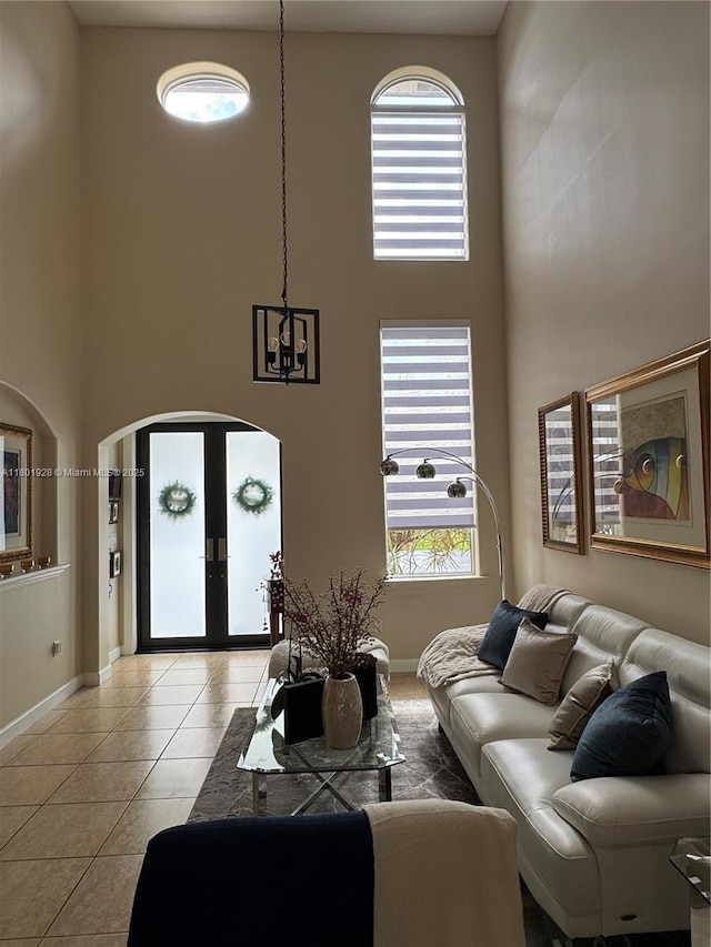 4892 NW 109th Pl, Doral, FL 33178 - living area featuring a high ceiling, french doors, light tile patterned floors, baseboards, and arched walkways