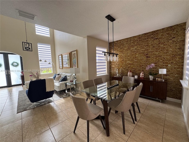 4892 NW 109th Pl, Doral, FL 33178 - dining area featuring light tile patterned floors, a textured ceiling, a chandelier, french doors, and arched walkways