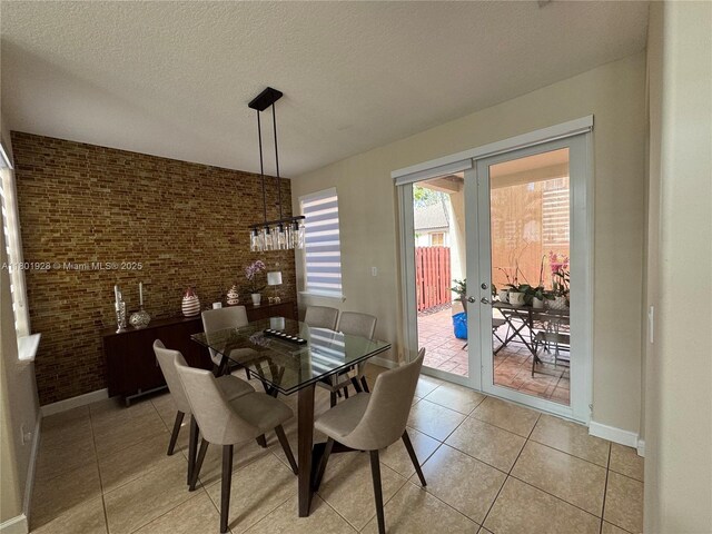 4892 NW 109th Pl, Doral, FL 33178 - dining area with light tile patterned floors, french doors, a textured ceiling, baseboards, and brick wall