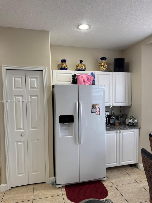 4892 NW 109th Pl, Doral, FL 33178 - kitchen featuring white refrigerator with ice dispenser, white cabinets, light tile patterned floors, a textured ceiling, and recessed lighting