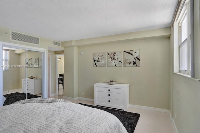 3001 S Ocean Dr Unit 321, Hollywood, FL 33019 - bedroom featuring multiple windows, a closet, baseboards, and a textured ceiling