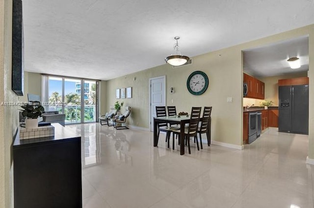 3001 S Ocean Dr Unit 321, Hollywood, FL 33019 - dining area with baseboards, floor to ceiling windows, and light tile patterned floors