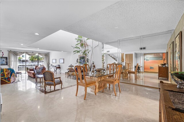214 Poinciana Dr Unit 204, Sunny Isles Beach, FL 33160 - dining room with stairs and a textured ceiling