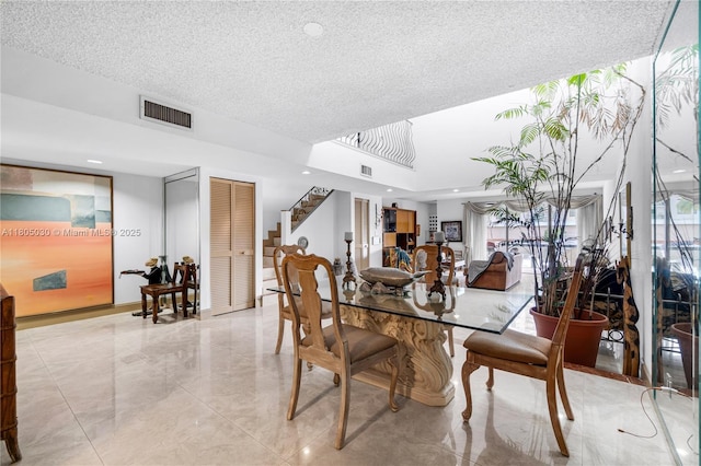 214 Poinciana Dr Unit 204, Sunny Isles Beach, FL 33160 - dining space with stairs, a textured ceiling, light marble finish flooring, and recessed lighting