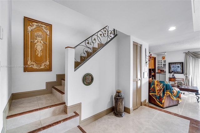 214 Poinciana Dr Unit 204, Sunny Isles Beach, FL 33160 - stairway with baseboards, recessed lighting, inlaid floor details, and tile patterned floors
