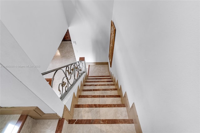 214 Poinciana Dr Unit 204, Sunny Isles Beach, FL 33160 - staircase featuring inlaid floor details and baseboards
