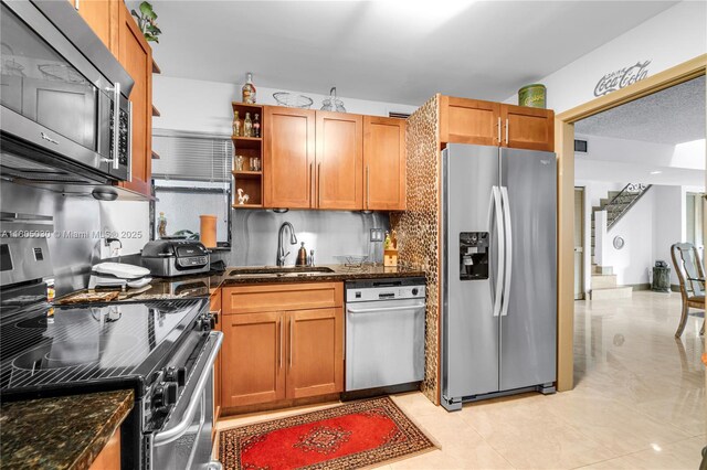214 Poinciana Dr Unit 204, Sunny Isles Beach, FL 33160 - kitchen with stainless steel appliances, a sink, decorative backsplash, and brown cabinets