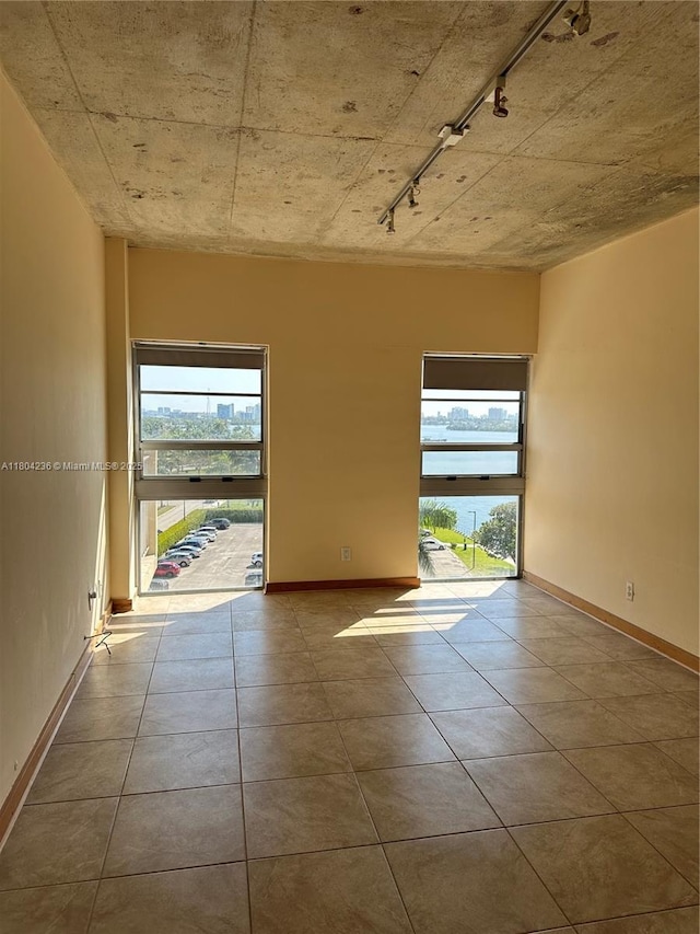 880 NE 69th St Unit 7Q, Miami, FL 33138 - unfurnished room with rail lighting, plenty of natural light, and baseboards