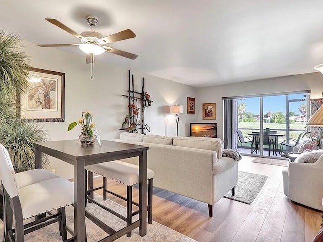 living area with wood finished floors and a ceiling fan