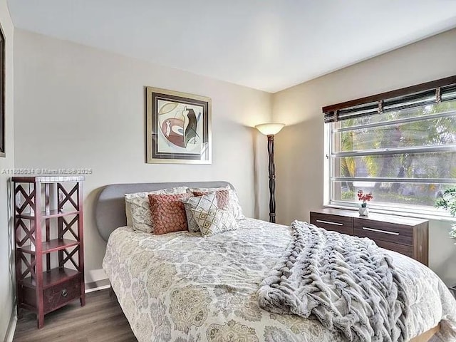 bedroom featuring wood finished floors and baseboards