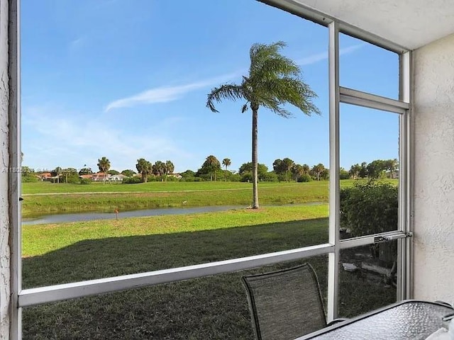 unfurnished sunroom featuring a water view