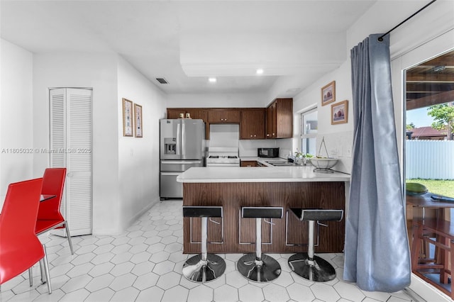 2023 SW 99th Ave, Miami, FL 33165 - kitchen with stainless steel fridge with ice dispenser, light countertops, a kitchen breakfast bar, a peninsula, and recessed lighting