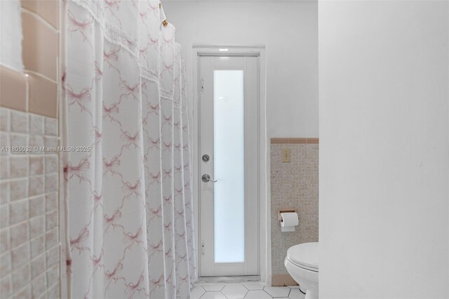 2023 SW 99th Ave, Miami, FL 33165 - bathroom featuring tile walls, tile patterned flooring, and toilet