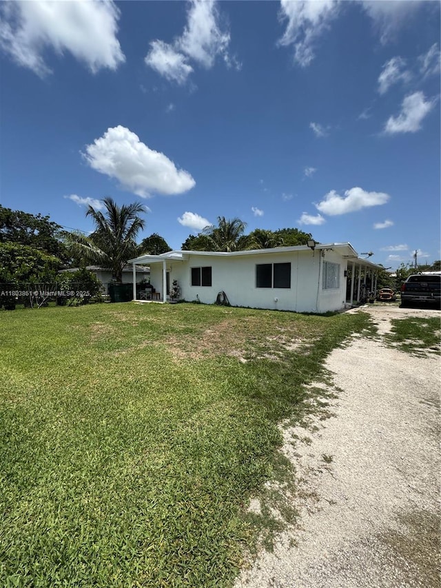554 SW 7th St, Florida City, FL 33034 - back of house featuring driveway, a yard, and stucco siding