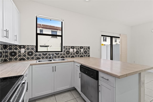 10611 W 33rd Ct, Hialeah, FL 33018 - kitchen featuring appliances with stainless steel finishes, a peninsula, light tile patterned flooring, decorative backsplash, and light countertops