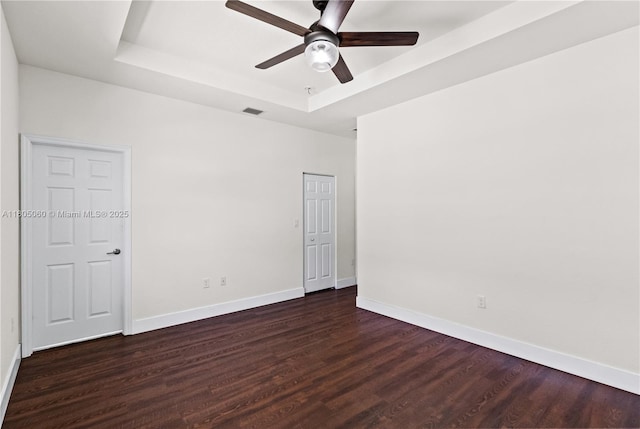 10611 W 33rd Ct, Hialeah, FL 33018 - unfurnished room featuring a tray ceiling, ceiling fan, and dark wood-style flooring