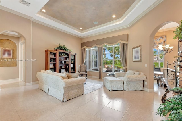12668 NW 74th Pl, Parkland, FL 33076 - living room featuring a tray ceiling, a chandelier, ornamental molding, arched walkways, and light tile patterned floors