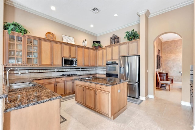 12668 NW 74th Pl, Parkland, FL 33076 - kitchen with stainless steel appliances, a sink, arched walkways, dark stone counters, and light tile patterned floors