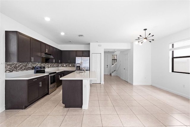 3435 W 110th St, Hialeah, FL 33018 - kitchen with stainless steel appliances, under cabinet range hood, backsplash, light countertops, and dark brown cabinetry