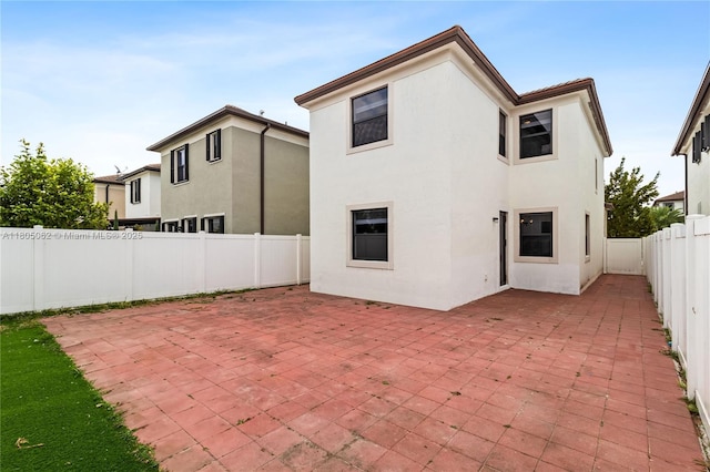 3435 W 110th St, Hialeah, FL 33018 - back of property with stucco siding, a patio, and a fenced backyard
