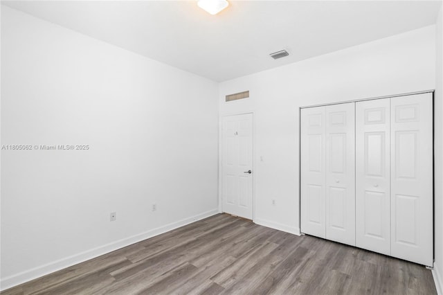 3435 W 110th St, Hialeah, FL 33018 - unfurnished bedroom featuring wood finished floors, a closet, and baseboards