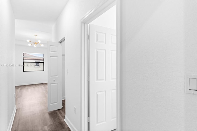 3435 W 110th St, Hialeah, FL 33018 - hallway featuring a chandelier, dark wood finished floors, and baseboards