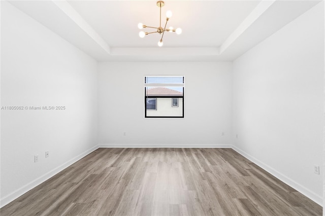 3435 W 110th St, Hialeah, FL 33018 - empty room with a chandelier, a raised ceiling, wood finished floors, and baseboards