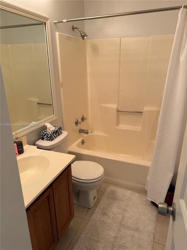 full bath with tile patterned floors, shower / bath combo with shower curtain, toilet, and vanity