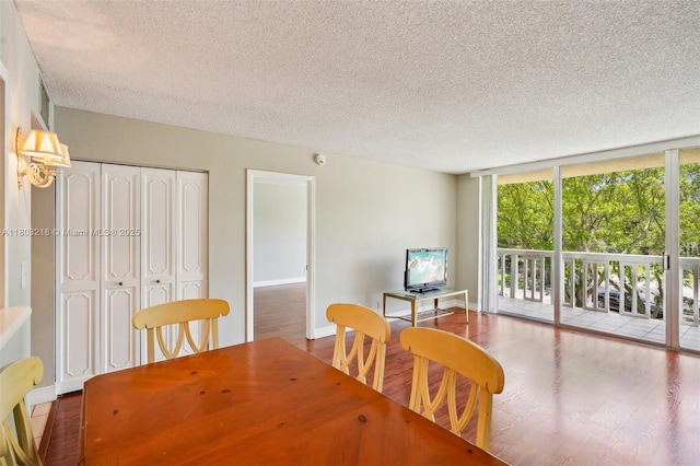 7081 Environ Blvd Unit 243, Lauderhill, FL 33319 - dining room featuring a textured ceiling, a wall of windows, wood finished floors, and baseboards