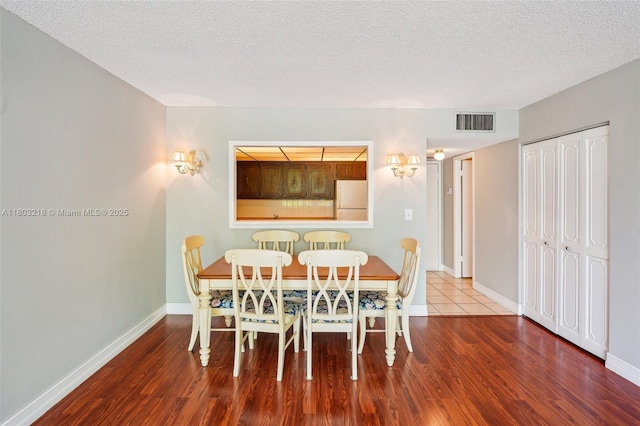 7081 Environ Blvd Unit 243, Lauderhill, FL 33319 - dining area featuring wood finished floors, a textured ceiling, and baseboards