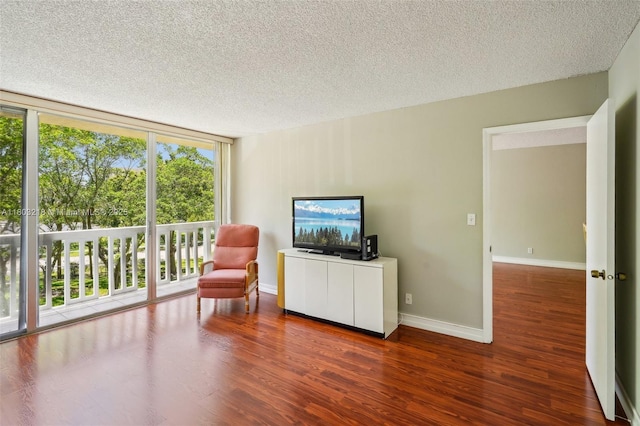 living area with a textured ceiling, wood finished floors, and baseboards