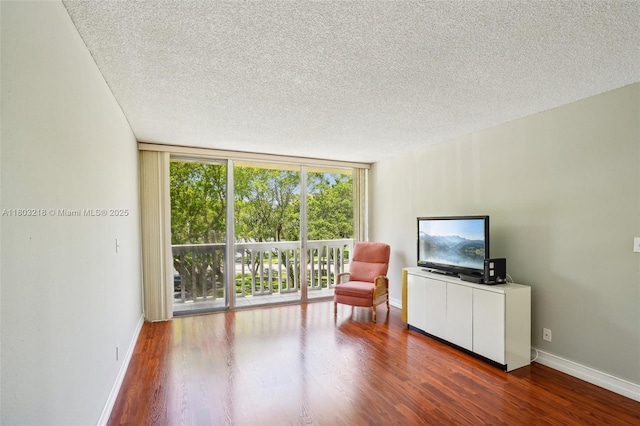 7081 Environ Blvd Unit 243, Lauderhill, FL 33319 - sitting room featuring a textured ceiling, floor to ceiling windows, baseboards, and wood finished floors