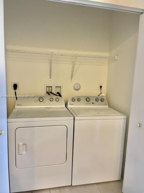 washroom with separate washer and dryer and light tile patterned flooring