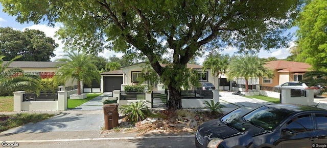 155 W 60th St, Hialeah, FL 33012 - view of front of property with a garage, a fenced front yard, driveway, and stucco siding