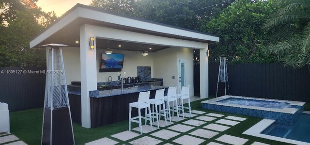 155 W 60th St, Hialeah, FL 33012 - patio terrace at dusk with a pool with connected hot tub and ceiling fan