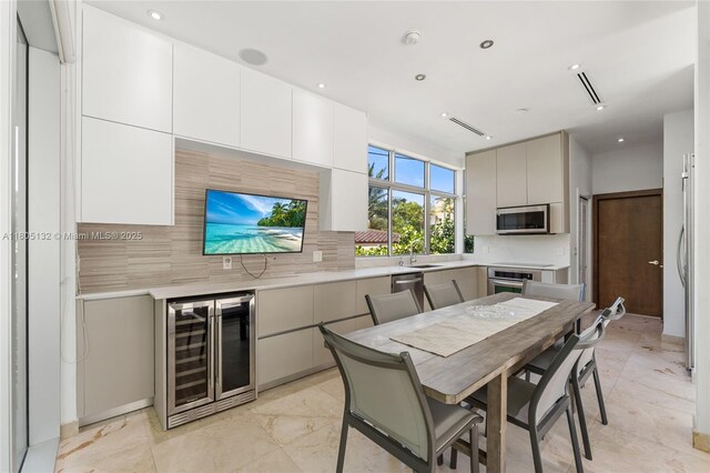 544 Fernwood Rd Unit 544, Key Biscayne, FL 33149 - kitchen with wine cooler, a sink, stainless steel appliances, tasteful backsplash, and light countertops