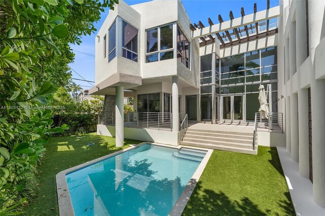 544 Fernwood Rd Unit 544, Key Biscayne, FL 33149 - back of house featuring stucco siding, an outdoor pool, and a lawn