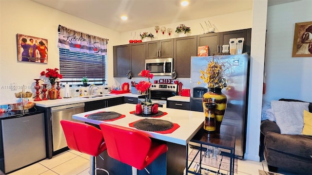 21463 NE 3rd Path, Miami, FL 33179 - kitchen featuring stainless steel appliances, a sink, light tile patterned flooring, light countertops, and a center island