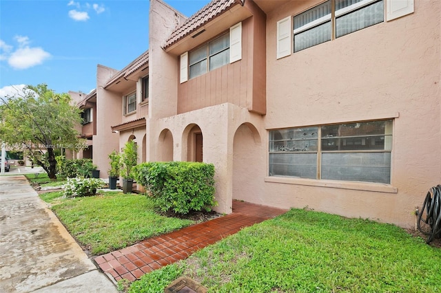 50 Matador Ln Unit 3-23, Davie, FL 33324 - view of front of property featuring stucco siding, a front lawn, and a tiled roof