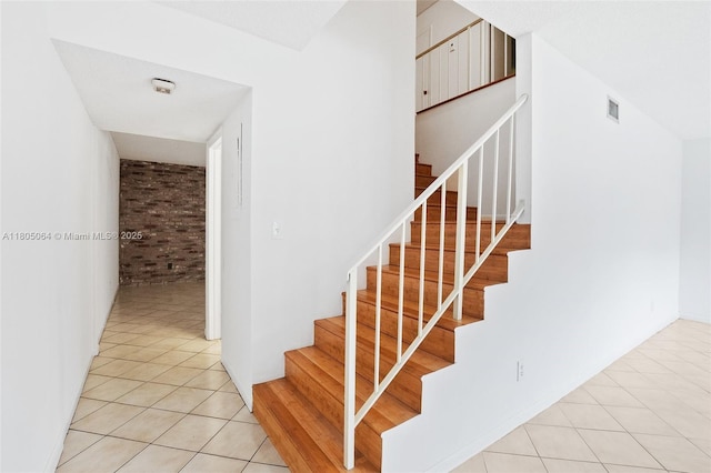 50 Matador Ln Unit 3-23, Davie, FL 33324 - staircase with brick wall and tile patterned flooring