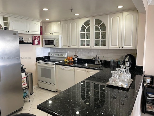 2625 Collins Ave Unit 1409, Miami Beach, FL 33140 - kitchen featuring white appliances, a sink, glass insert cabinets, white cabinets, and tasteful backsplash