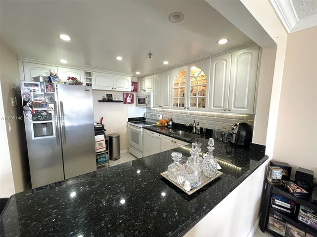 2625 Collins Ave Unit 1409, Miami Beach, FL 33140 - kitchen featuring white appliances, a sink, dark stone countertops, backsplash, and recessed lighting