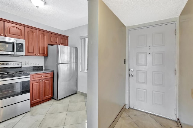 8720 N Sherman Cir Unit 401, Miramar, FL 33025 - kitchen featuring appliances with stainless steel finishes, a textured ceiling, and light tile patterned flooring