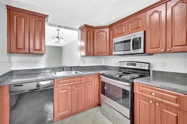 8720 N Sherman Cir Unit 401, Miramar, FL 33025 - kitchen with stainless steel appliances, a chandelier, light tile patterned flooring, dark countertops, and brown cabinetry