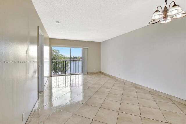 8720 N Sherman Cir Unit 401, Miramar, FL 33025 - unfurnished room with a chandelier, light tile patterned flooring, a textured ceiling, and a smoke detector