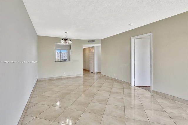 8720 N Sherman Cir Unit 401, Miramar, FL 33025 - unfurnished room with a chandelier, light tile patterned floors, a textured ceiling, and a smoke detector