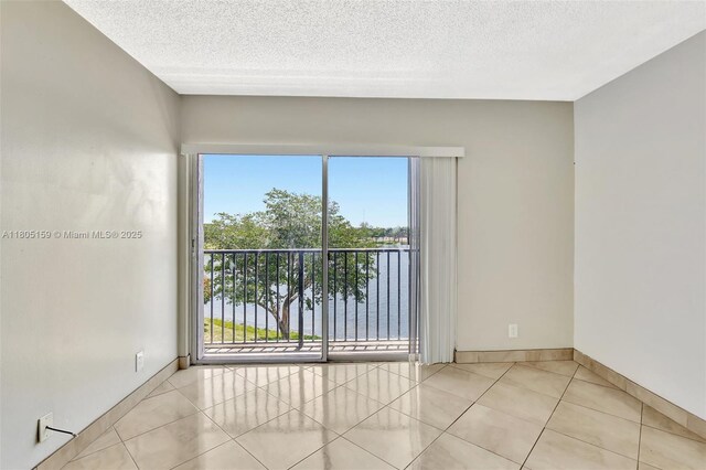8720 N Sherman Cir Unit 401, Miramar, FL 33025 - tiled spare room featuring a textured ceiling and healthy amount of natural light