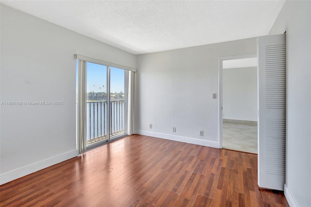 8720 N Sherman Cir Unit 401, Miramar, FL 33025 - spare room featuring wood finished floors and a textured ceiling